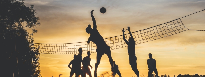 silhouette of people playing basketball during sunset