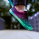 selective focus photography of person wearing multicolored sneakers while jumping