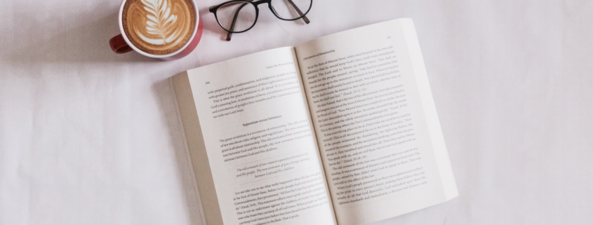 book near eyeglasses and cappuccino