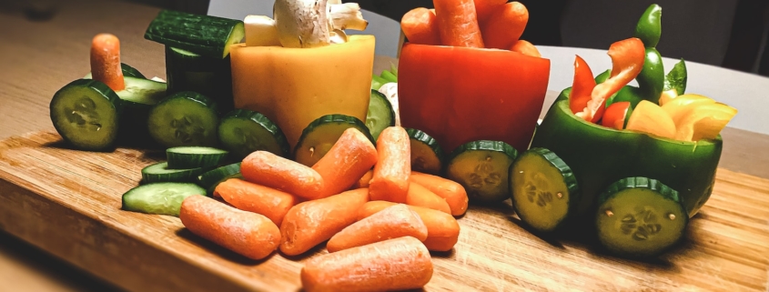 sliced carrots and green bell pepper on brown wooden chopping board