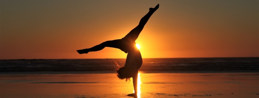 woman in white dress standing on beach during sunset