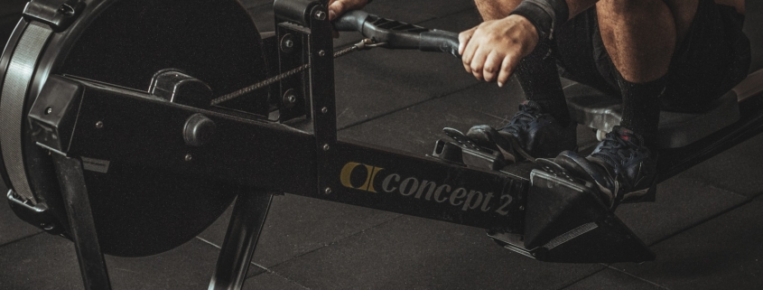 topless man using rowing machine